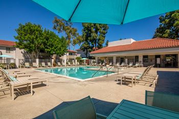 A sunny day at the pool with lounge chairs and umbrellas.